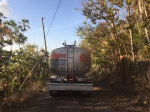 A water truck navigates loosely paved roads while delivering gallons of water to a V.I. resident. (Kelsey Nowakowski photo)