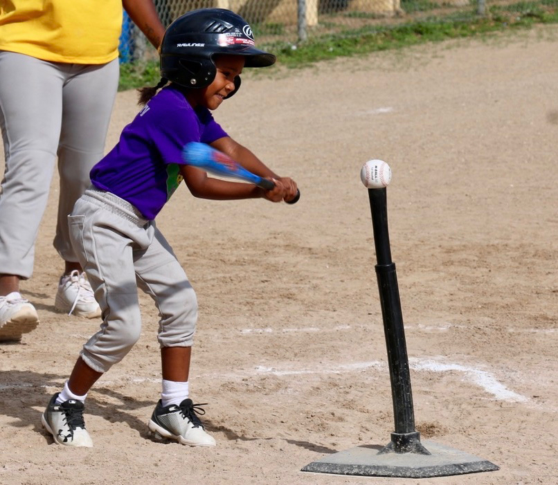 Five-year-old Ivaleeze Lampe takes a full swing at the teed-up baseball as she bats for the Diamond Dolls.