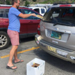 Stephen Libbey cleans up glass from a co-worker’s car. by Amy Roberts