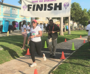 First lady Yolanda Bryan crosses the finish line, followed closely by her bodyguard. (Elisa McKay photo)