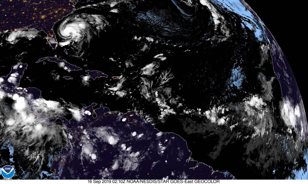 Satellite photo shows low pressure system, lower right, bringing rain clouds across the Atlantic. Hurricane Humberto is in the upper left moving northwest towards the Carolinas. (NOAA image)