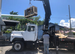 Michael Marsh uses his crane to install a generator at the St. John shelter. (Source photo Amy Roberts)