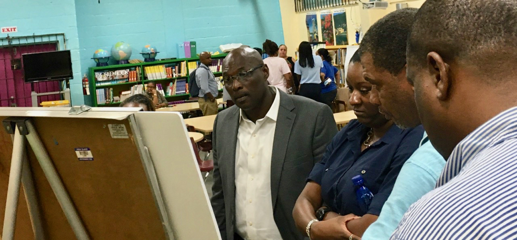Sens. Novelle Francis, Kenneth Gittens and Kurt Vialet look over displays at Tuesday's Department of Education community meeting. (Source photo by Susan Ellis)
