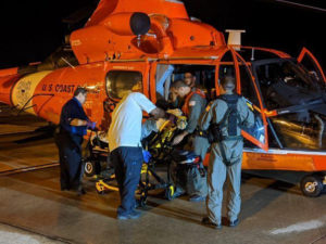 The crew of a U.S. Coast Guard MH-65 Dolphin helicopter assists a crew member of the Marella Eplorer 2 Cruise ship. The crew member had been stricken by a heart attack at sea and was medevaced to St. Croix, where he was treated at the Juan F. Luis Hospital. (U.S. Coast Guard photo)