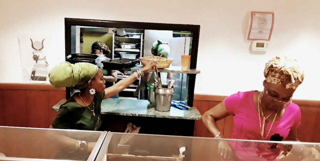 Isumyah Schrader's daughters, Ama and Amibala, serve customers. (Source photo by Darshania Domingo)