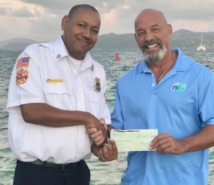 Clarence Stephenson receives a $5,000 check from Dominick DeDominicis of Haugland Virgin Islands for an STJ children’s Christmas party. (Photo by VIFS)