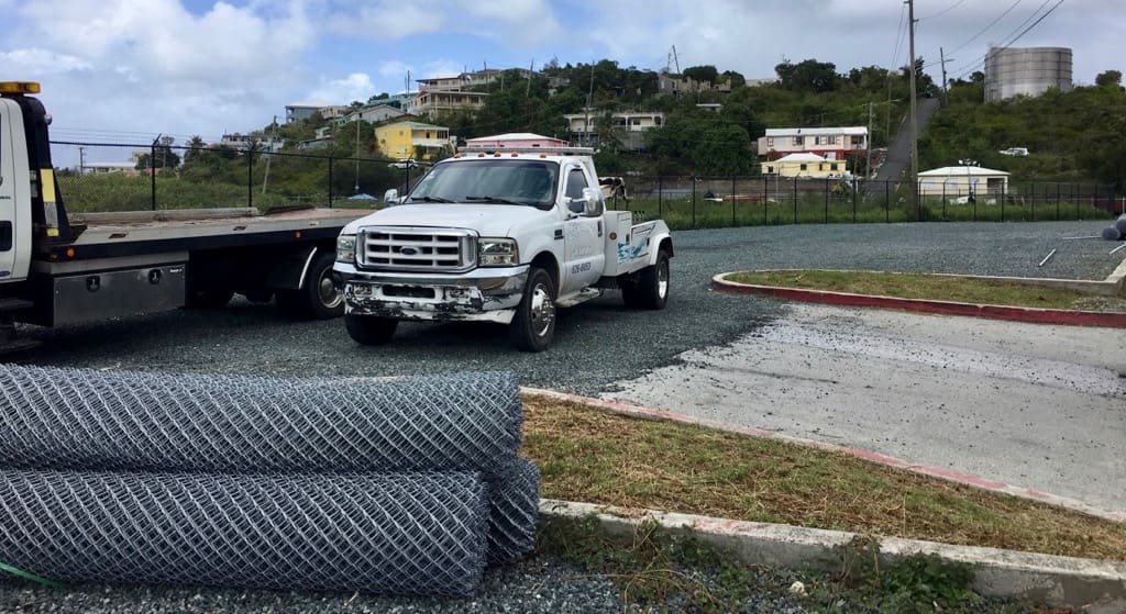 Vehicles block a major entrance to the gravel lot. (Source photo by Amy Roberts)