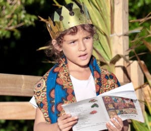 As one of the Three Wise Men, Kaiden Castillo wears a golden crown during “We Three Kings of Orient Are.” (Source photo by Linda Morland)