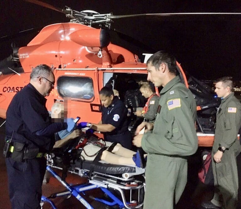 The crew of a Coast Guard MH-65 Dolphin helicopter from Air Station Borinquen transfers a 68-year-old man to emergency medical service personnel at the airport in San Juan, Puerto Rico. The man is a U.S. citizen who was a passenger aboard the Queen Mary 2 and was medically evacuated. (U.S. Coast Guard photo)