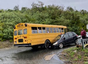 A school bus and a private vehicle are locked together after an accident on Cassie Hill. (Photo supplied by a Source reader)