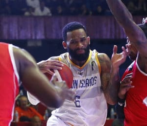 USVI point guard Walter Hodge battles past a pair of Cuban defenders in Friday's game in Havana. (Photo by FIBA)