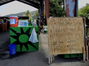 Shoppers at the Bordeaux farmers market were greeted by a sign urging sanitation and keeping a distance, and a table with all the necessities for a good hand scrub, (Source photo by S. Pennington)