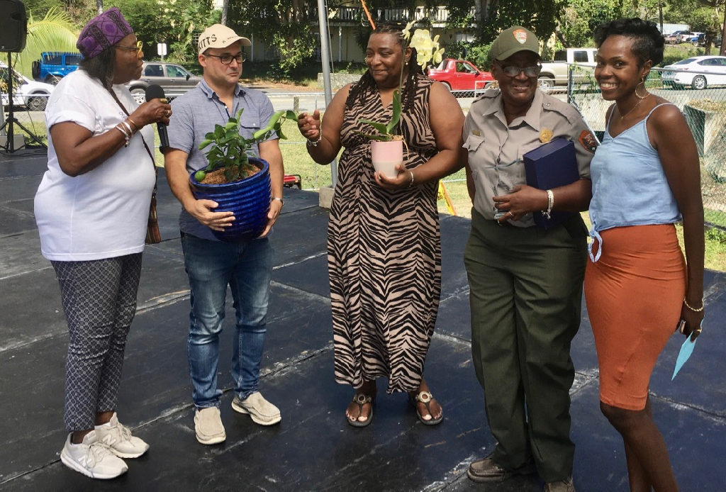 Golda Hermon, second from right in NPS uniform, is recognized for her work organizing the 29th Folklife Festival by St. John Community Foundation members, from left, Alecia Wells, Jon Eichner and Abigail Hendricks, and Dior Parsons, right. (Source photo by Amy Roberts)