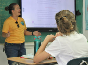 Kitty Edwards from the Department of Planning and Natural Resources’ Coastal Zone Management Division speaks to an eighth grade class about the importance of waste reduction. (Source photo by Bethaney Lee)
