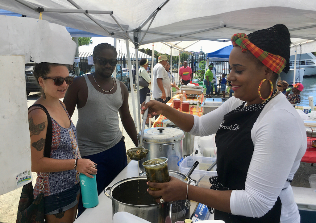 Luciah Polius serves up kallaloo to Darby Rutledge and Adiso Henry. (Source photo by Amy Roberts)