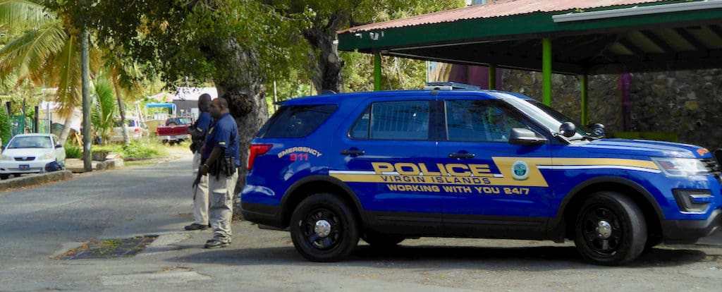 Police officers keep watch at the Fish Market entrance to Hospital Ground Saturday morning. (Source photo by S. Pennington)