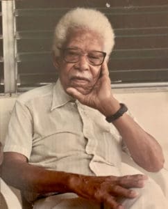 Ogese McKay reclines on his porch at Work & Rest, Christiansted. (Photo by Elisa McKay)