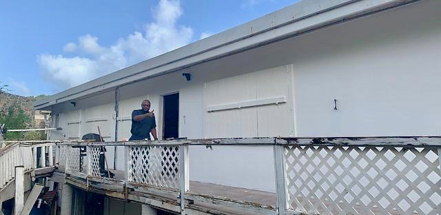 The Rev. Anthony Abraham gives the thumbs up as the congregation begins repairs on Charity House near Cruz Bay. photo provided by OLMC Catholic Church. (Source photo by Amy H. Roberts)