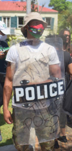 A protesterin police riot gear asks “Who Police the Police? (Source photo by Kyle Murphy)