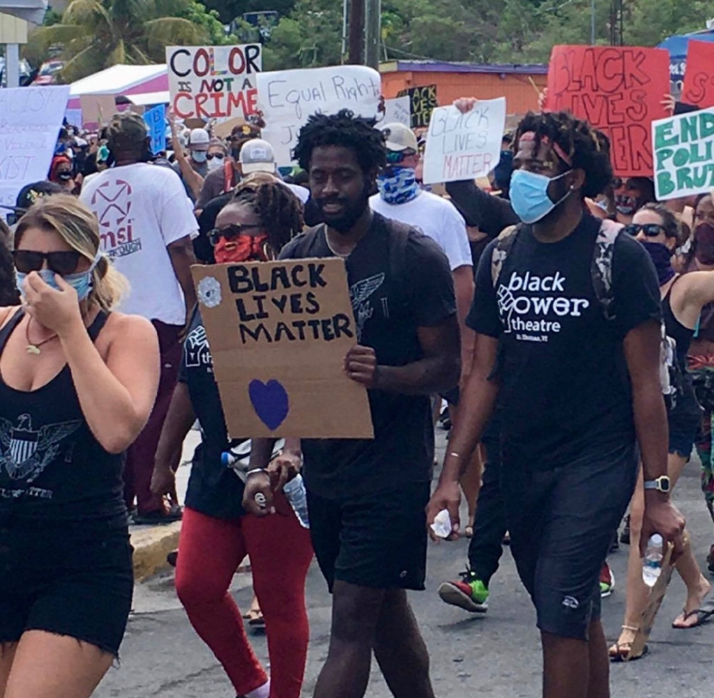 Marchers carry signs promoting their cause. (Photo by Lisa Etre)