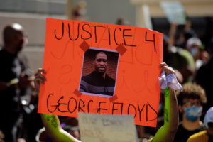 A protester holds a sign calling for justice for George Floyd during a march in Miami. Protests have taken place in cities across the country and around the world since Floyd's death while in police custody. (Shutterstock image)