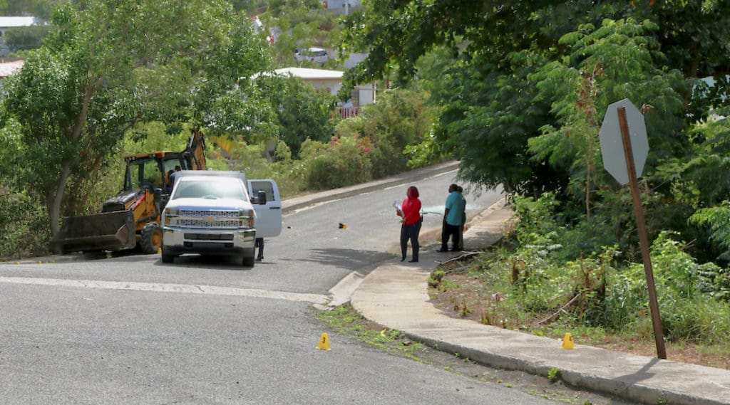 Police Detectives and employees of the Medical Examiners office work the scene of a shooting at which 29-year-old Rique Ashby and 14-year-old Aaron Ashby died of gunshot wounds. (VIPD photo)