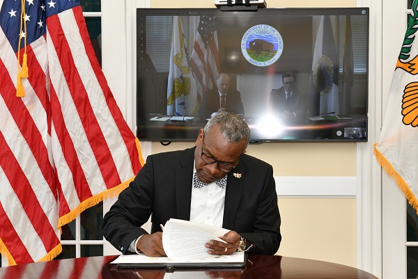 Gov. Albert Bryan, Department ofInterior Assistant Secretary for Fish and Wildlife and Parks Rob Wallaceand Assistant Secretary for Insular and International Affairs Douglas W. Domenech sign a preliminary agreement for a land swap in St. John between the National Park Service and the Government of the Virgin Islands.