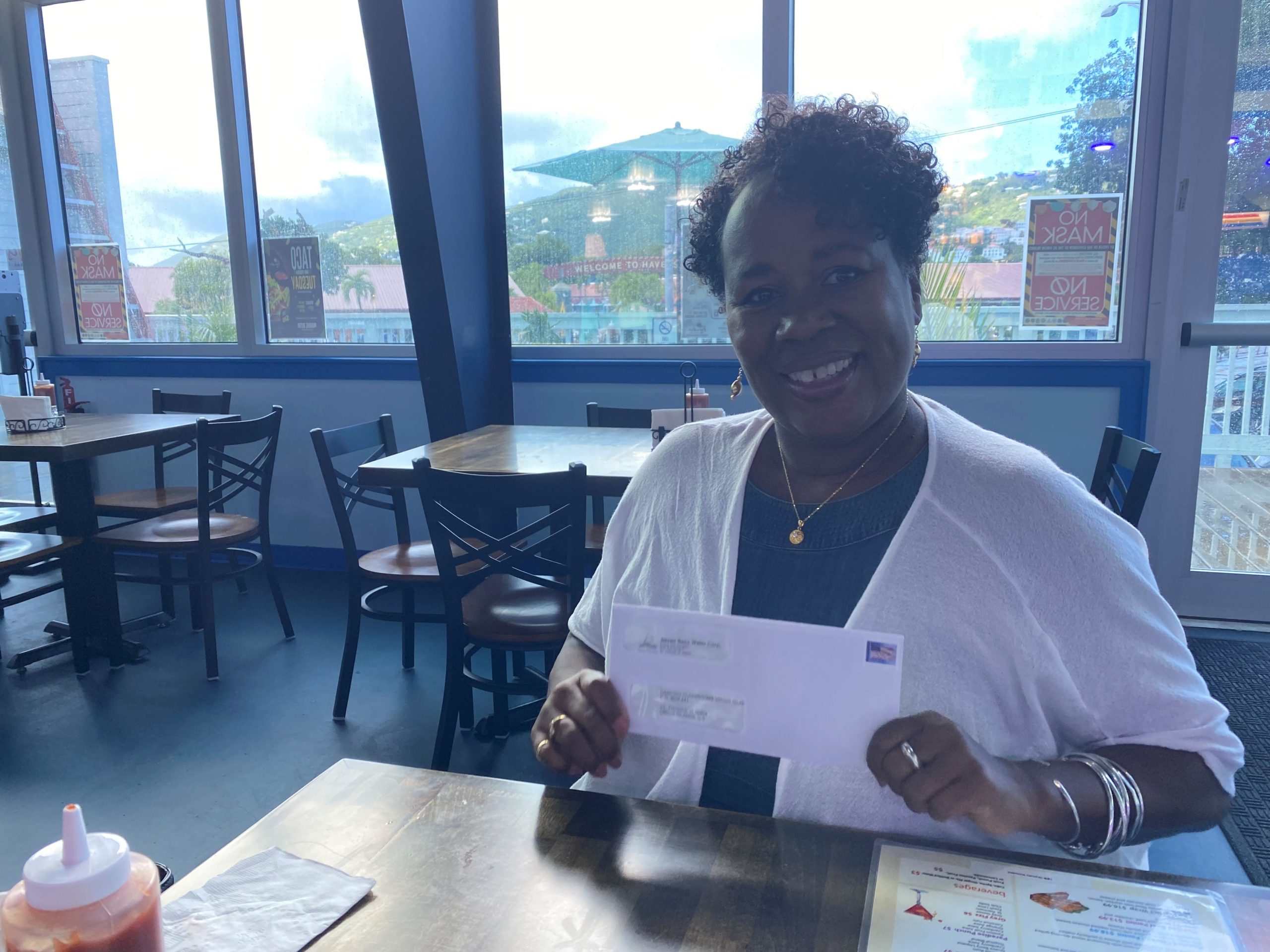 Patricia Rockwood of Dancing Classrooms displays a check received from Seven Seas Water in support of the program. (Photo by Seven Seas Water)