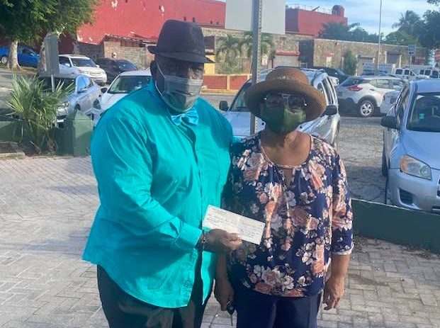 Edgar Baker Phillips of the Democratic Club presents a check for $500 to Francine Penn-Scipio for the Thanksgiving community dinner the family holds each year at Emancipation Garden. (Photo courtesy of Edgar Philips)