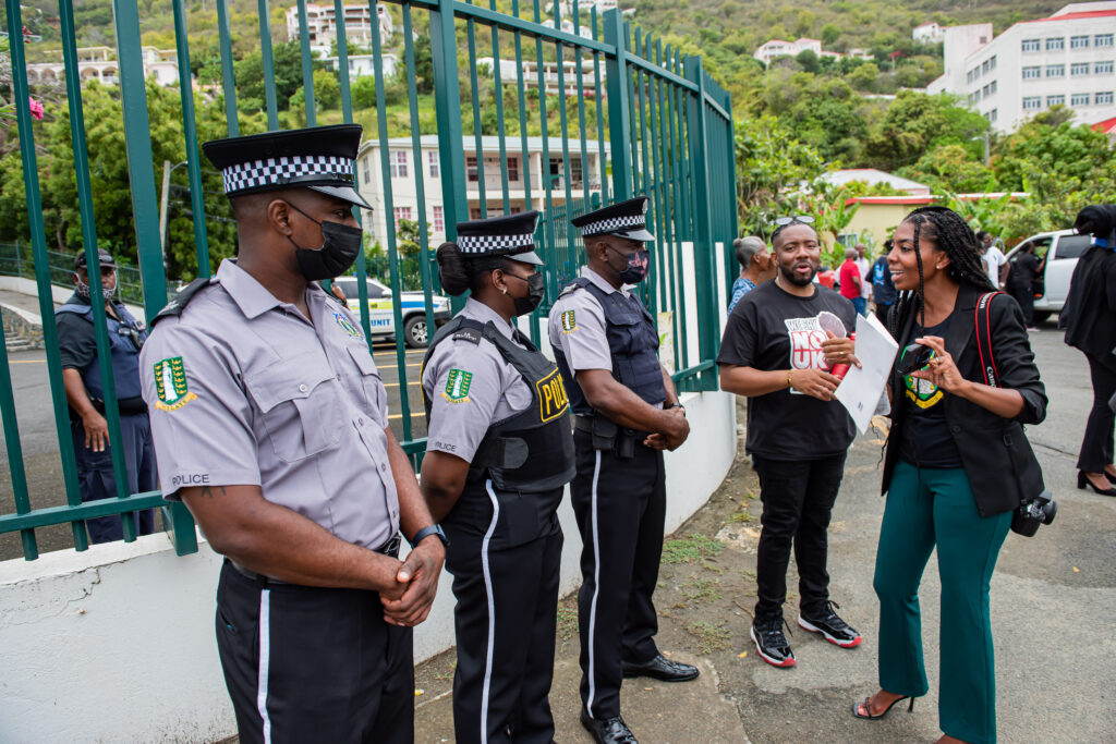 Police officers stand guard outside Government House on Tortola in the British Virgin Islands on Monday as protesters took to the street. (Photo by Cleave)