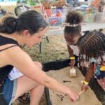 Children doing sensory play in the sand box at the DPNR booth at the 50th Agricultural Fair in St. Croix