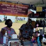 Debra Parris and Jean Laviscount, of Styles of Distinction, take a break between customer visits at the 50th Agricultural Fair in STX.