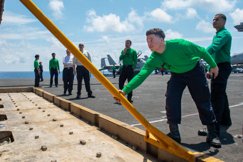 Aviation Boatswain's Mate (Equipment) Airman Oliver Tejada, from Saint Croix, places a stanchion for a jet blast deflector on the flight deck of USS Harry S. Truman (CVN 75) on June 9 in the Ionian Sea.