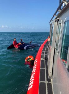 A Coast Guard Boat Forces Detachment St. Croix boat crew rescues a person from the water following a vessel capsizing offshore from Green Cay Marina in St. Croix, U.S. Virgin Islands July 17, 2022. A Coast Guard and two Good Samaritan vessels joined efforts to rescue three men and two women, after a 21-foot pleasure craft capsized when hitting a wave at high speed. (U.S. Coast Guard photo.)