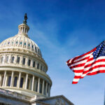 American,Flag,Waving,With,The,Capitol,Hill,In,The,Background