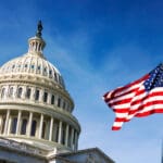 American,Flag,Waving,With,The,Capitol,Hill,In,The,Background