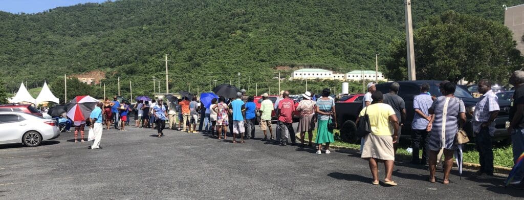 Senior citizens line up in the to sun to receive Social Security stipend checks Wednesday in the parking lot at Schneider Regional Medical Center on St. Thomas. The same scene played out on St. Croix. (Source photo by Sian Cobb)