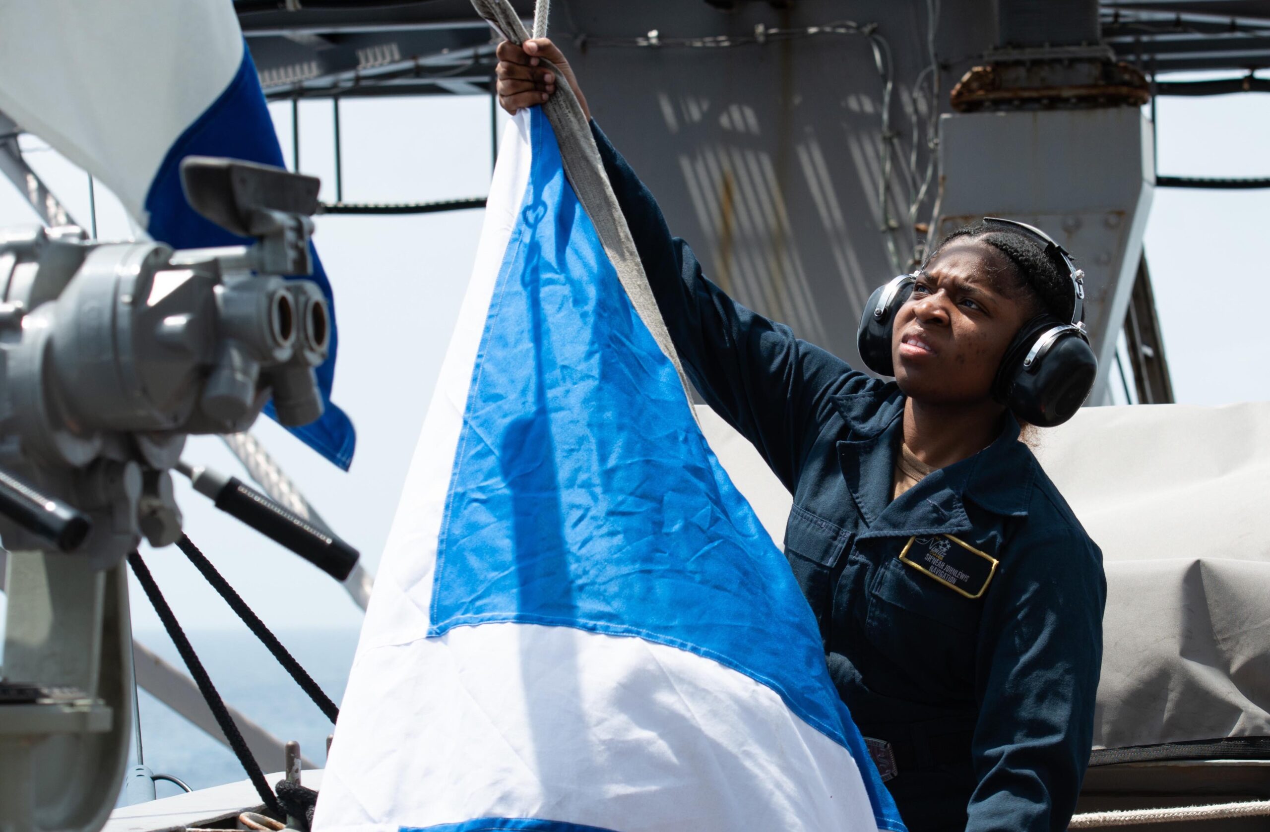 Quartermaster Seaman Sh'neah Johnlewis, from St. Croix, raises pennants aboard the aircraft carrier USS Nimitz on Wednesday in the South China Sea. (U.S. Navy photo by Mass Communication Specialist 2nd Class Caitlin Flynn)