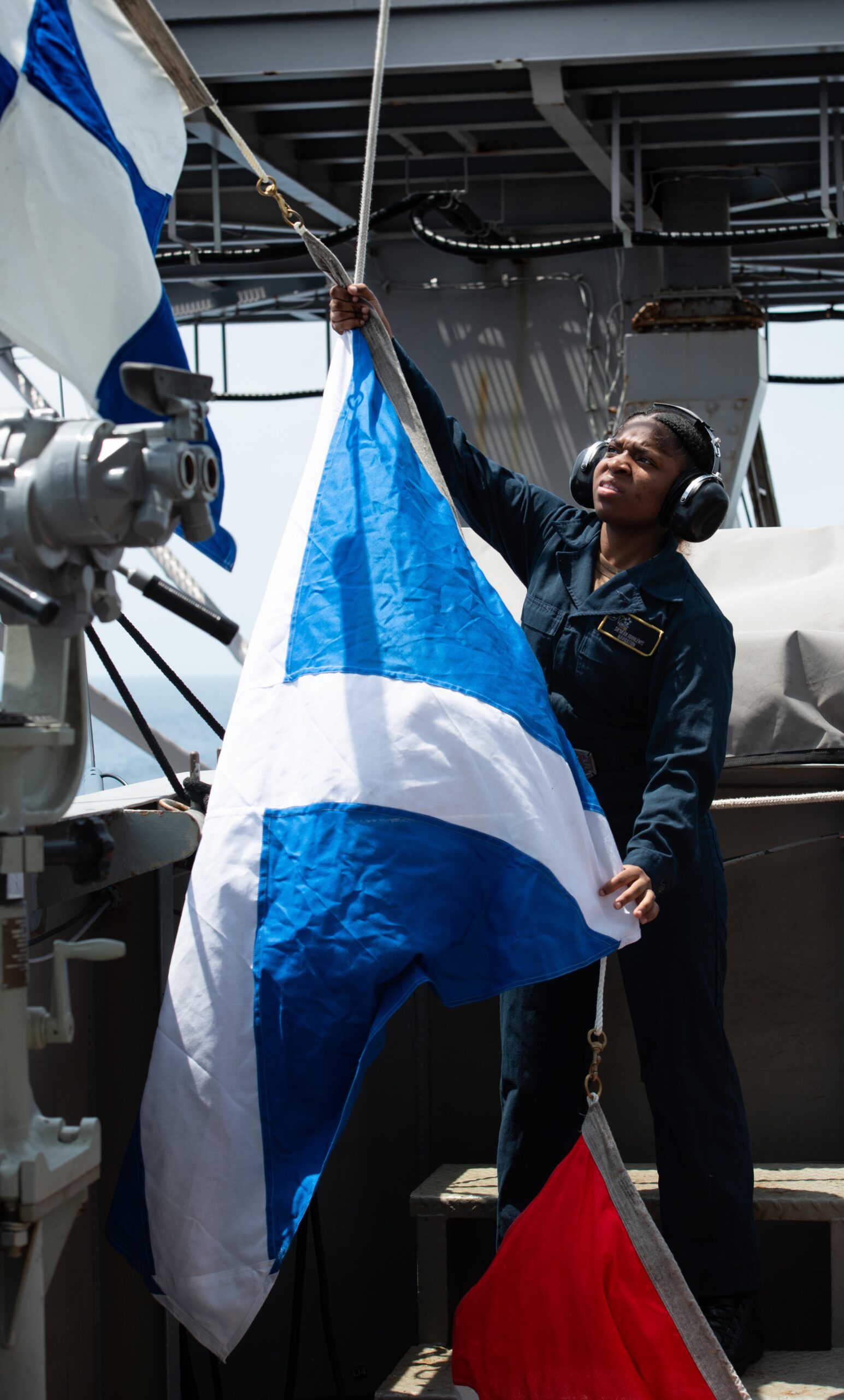 Quartermaster Seaman Sh'neah Johnlewis, from St. Croix, raises pennants aboard the aircraft carrier USS Nimitz on Wednesday in the South China Sea. (U.S. Navy photo by Mass Communication Specialist 2nd Class Caitlin Flynn)
