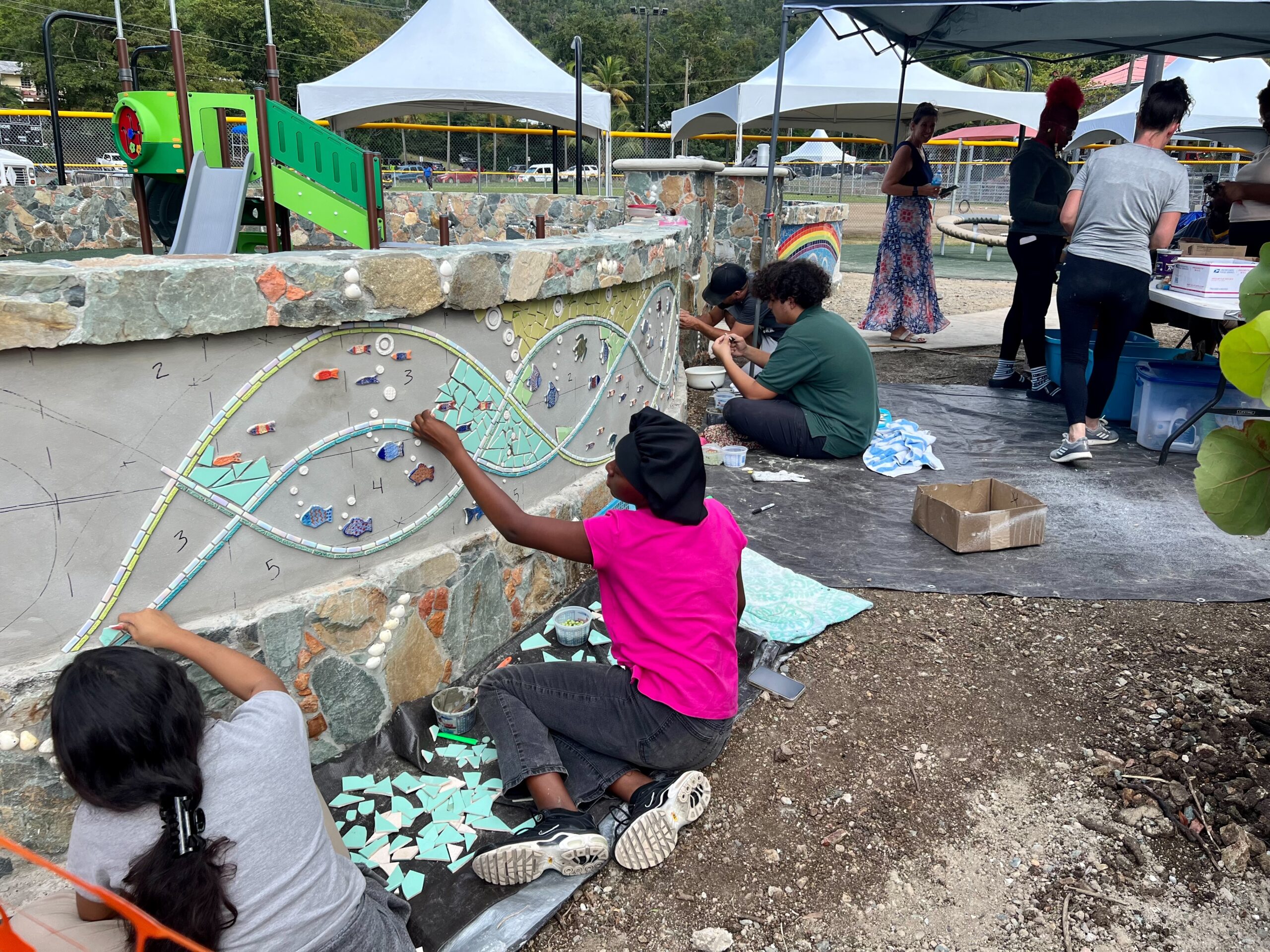 Gifft Hill students work on a mosaic at the new playground in Cruz Bay. (Source photo by Amy H. Roberts)