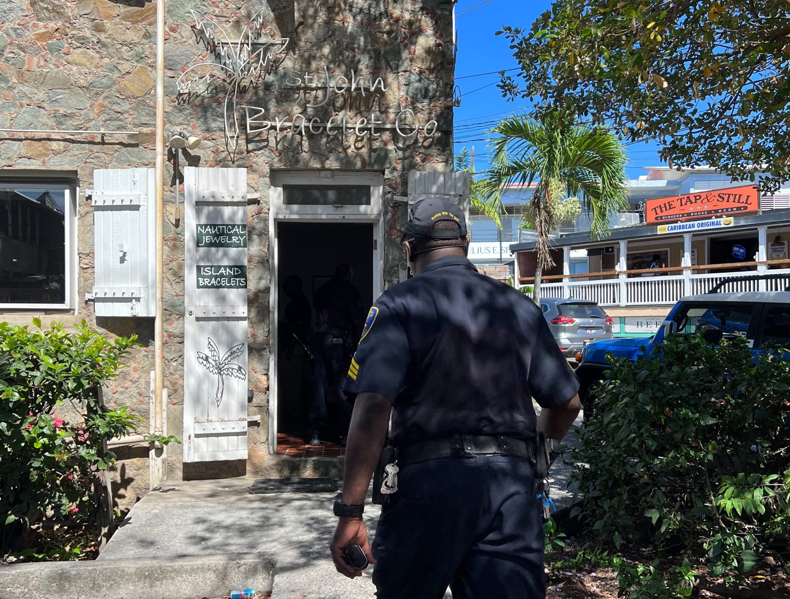 A V.I. Police officer investigates after the daylight robbery of the St. John Bracelet Co. in Cruz Bay on Thursday. (Submitted photo)