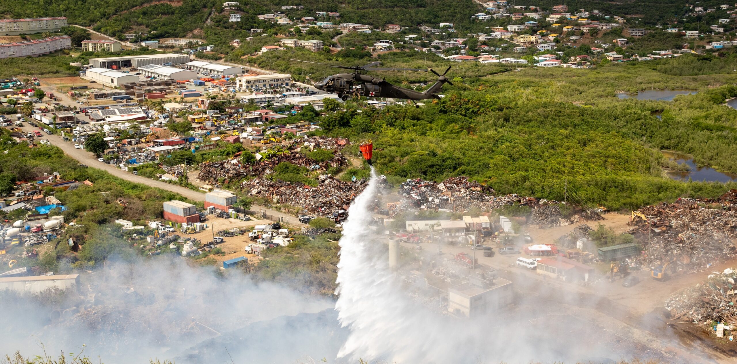 Crews with the Puerto Rico National Guard drop water on the Bovoni landfill fire on Wednesday. (Photo courtesy Government House)