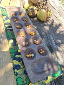 In earlier days, holes were made in the ground, and the game was played with small shells, stones, and nickel. Later, Oware boards were made from mahogany. These Wahree boards were made by Joy Stanley. I love the wahree board with St. Croix. (Photo by Olasee Davis)