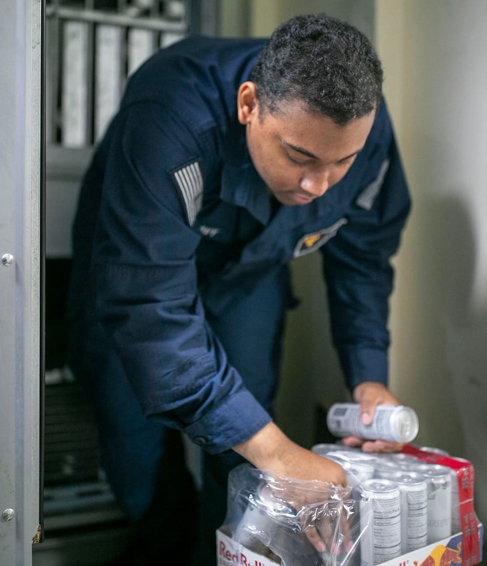 Govia selects cans of Red Bull to place in the vending machines aboard the USS Tripoli, which is serving in the Pacific. (U.S. Navy photo by Mass Communication Specialist Seaman Paul LeClair)