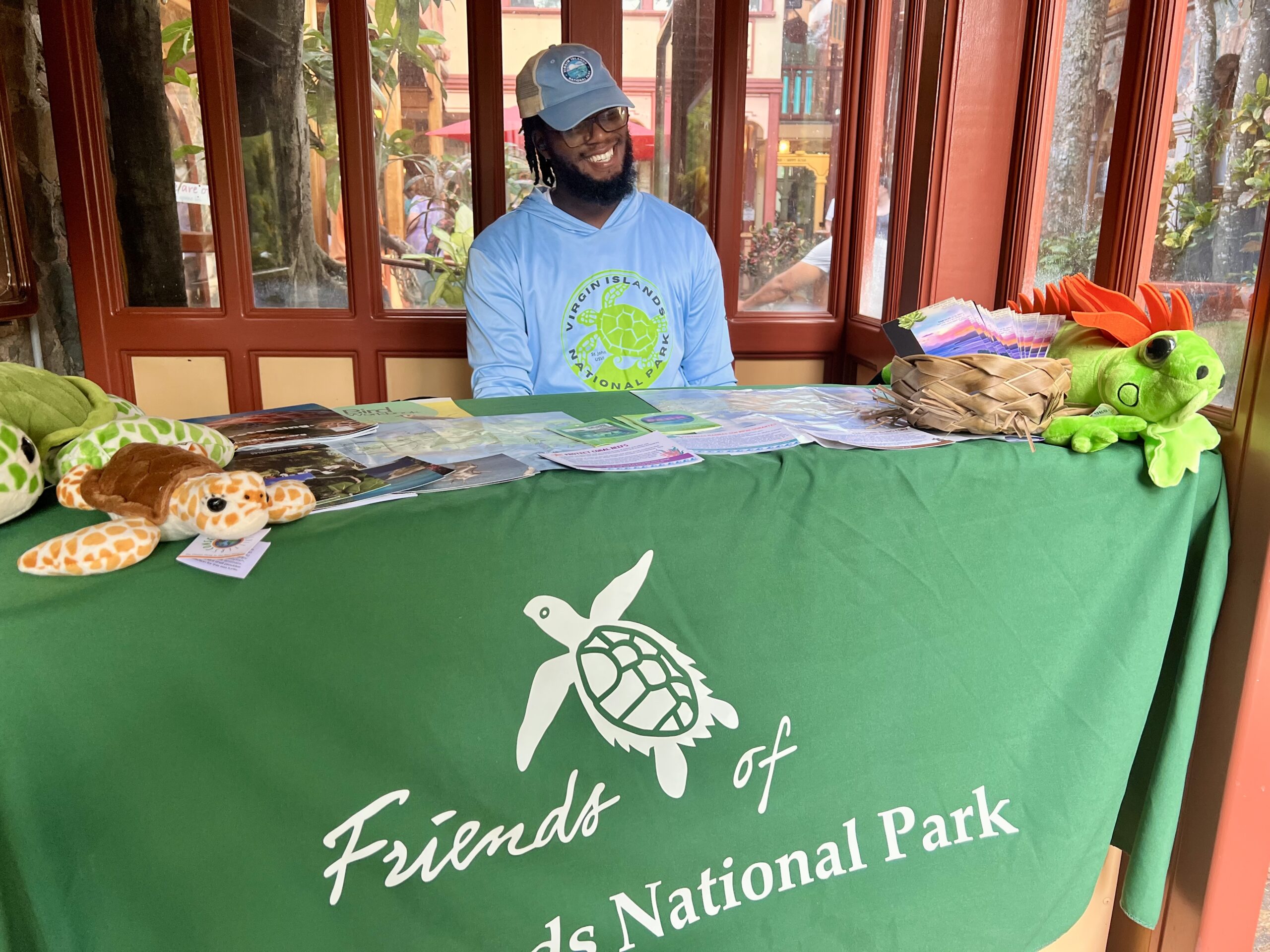 Bookstore attendant Ethan Popo directs visitors to the Friends of the V.I. National Park pop-up store at Mongoose Junction on St. John. (Source photo by Judi Shimel)