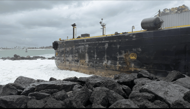 The fuel barge Defiant sits on the rocks at the entrance to San Juan Harbor after running aground on Monday. (Photo courtesy Coast Guard)