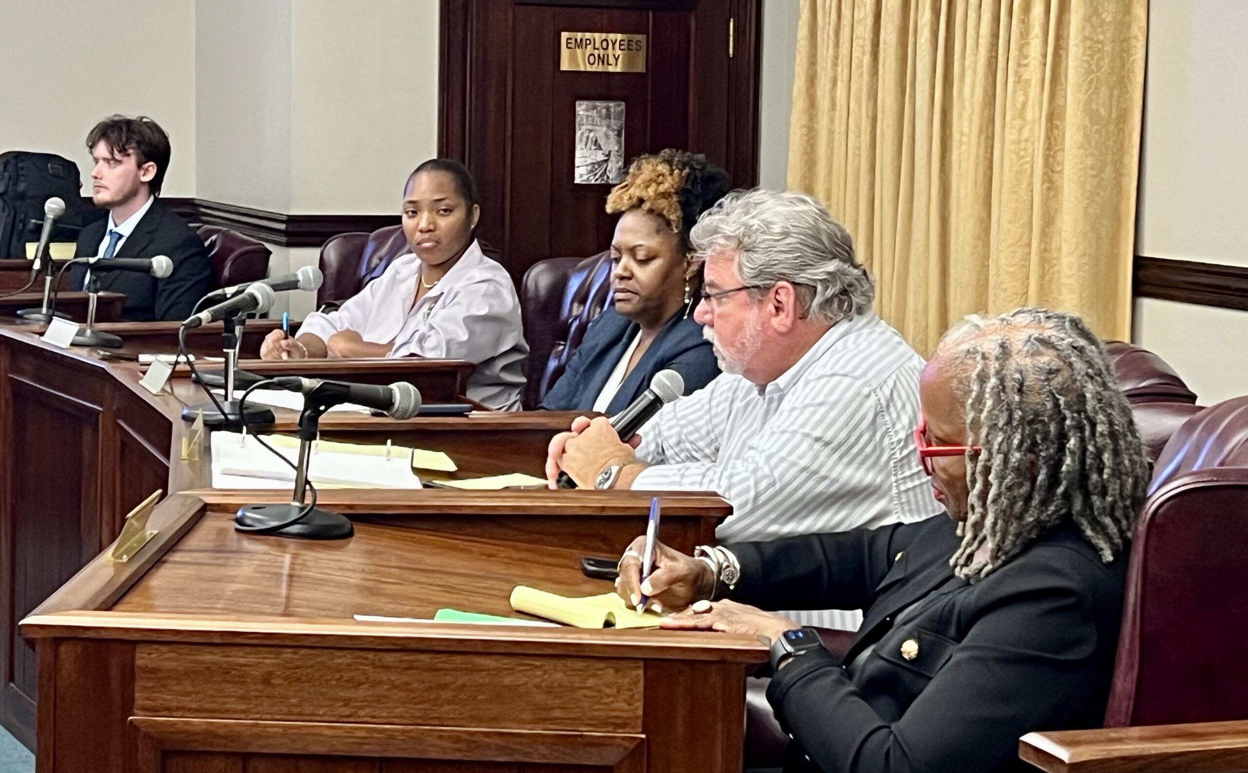 Members of the Public Services Commission staff listen as attorney Boyd Sprehn testifies at Monday’s hearing. (Source photo by Amy H. Roberts)