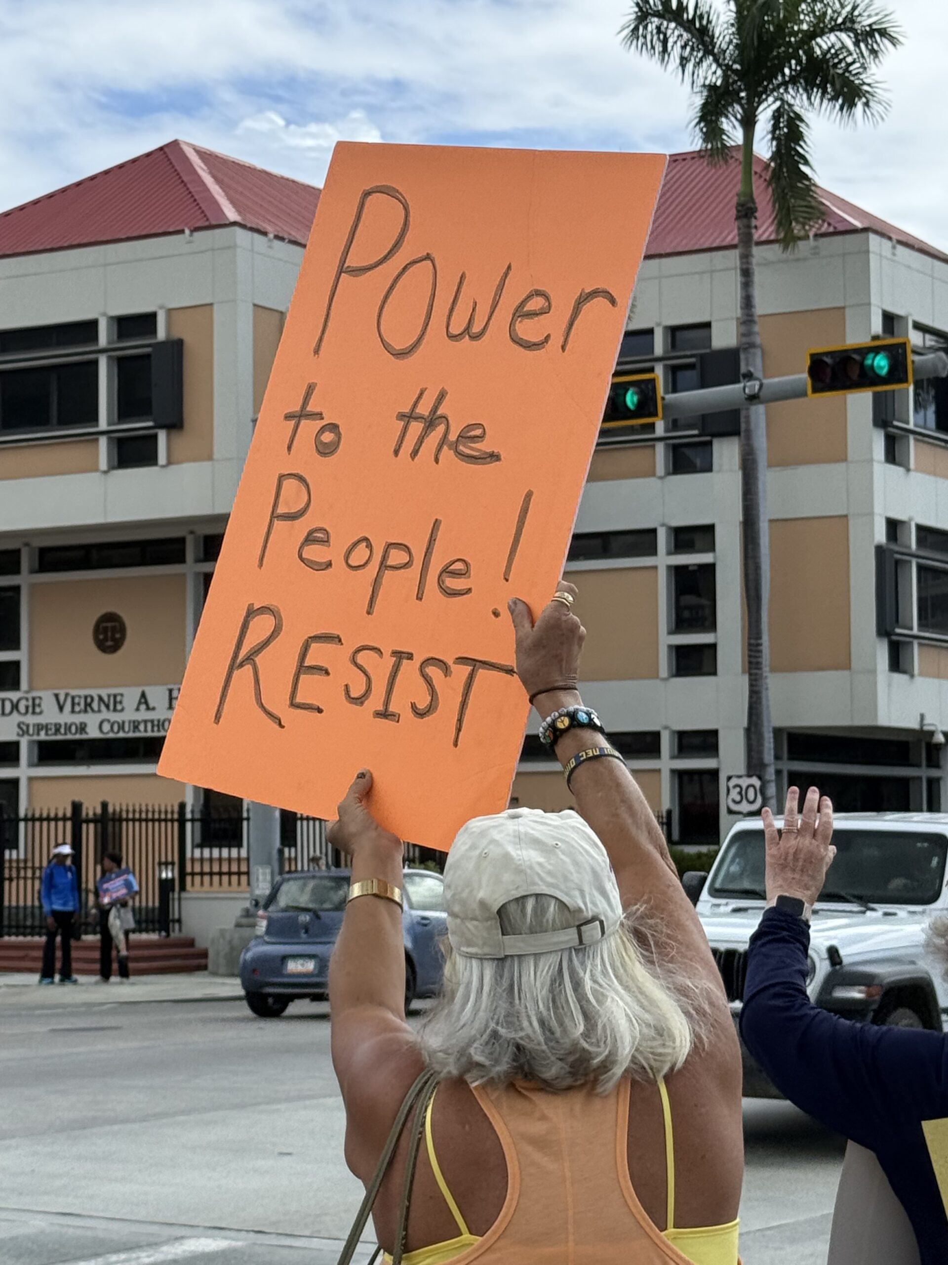 A No Kings rally participant gets the attention of passing motorists during the protest Saturday on St. Thomas. (Photo courtesy Jane Higgins)