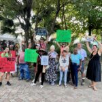 St. John residents hold signs in park. Amy H. roberts